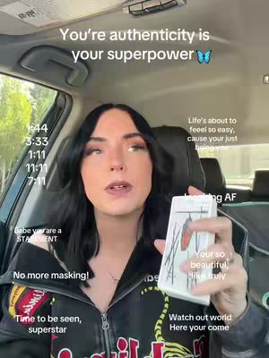 A woman with dark hair and a black jacket is seated inside a car, holding a tarot card. The image is overlaid with multiple text elements and timestamps against a backdrop visible through the car's windows.