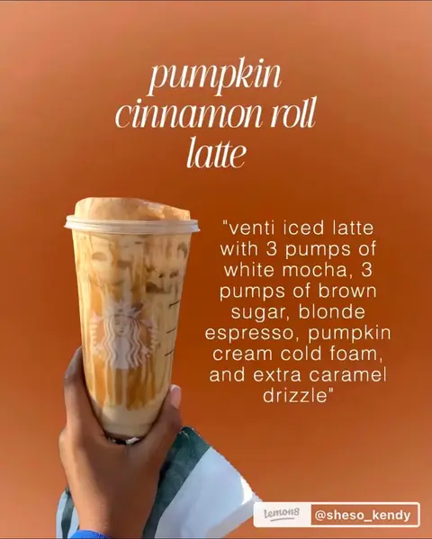 An overhead shot features a venti Starbucks cup filled with a layered drink. The drink appears to be a latte with various components visible, including lighter and darker brown tones, and is held by a person with a dark skin tone. The person's well-manicured hand holds the cup. The background is a solid shade of orange, and the overall composition gives the impression of a fall-themed beverage presentation.