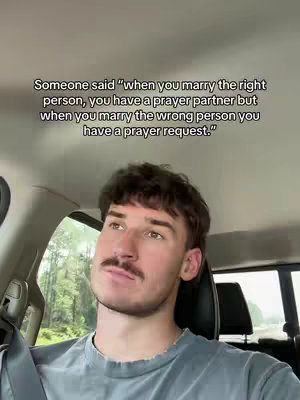 A man looking up thoughtfully from inside a car, text overlayed. The man has short hair, a mustache, and is wearing a grey shirt. The car's interior and the outdoor scenery through the windows are visible.