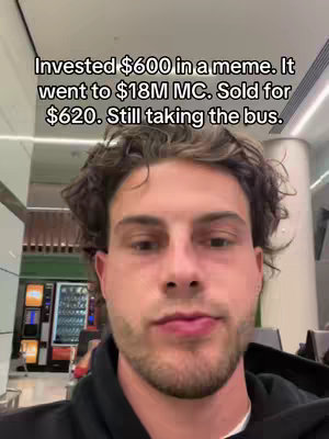 A man with brown hair and a neutral expression stands in front of a blurry background with vending machines visible. Text overlayed reads stats.