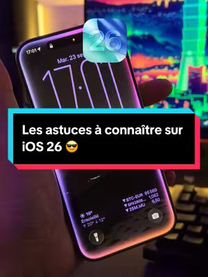 The cover image features an iPhone displaying its lock screen with the time, date, and weather information. A black rectangle with white text overlaid towards the bottom, with the text "Les astuces à connaître sur iOS 26 😎". In the upper right corner, an iOS 26 logo is superimposed. The background is blurred, featuring a screen and other objects, with the creator's hand holding the iPhone.