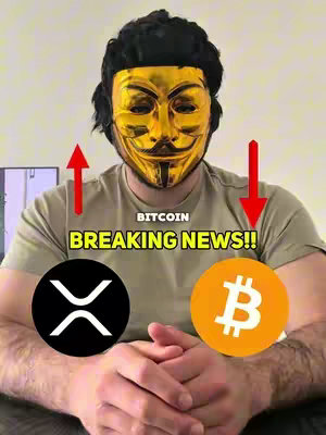 A person wearing a golden mask is centered in the frame. The mask is a gold rendition of the Guy Fawkes mask. The background appears to be a neutral light color. The individual is wearing a t-shirt with two digital crypto currency logos positioned below, one branded XRP and the other Bitcoin. Above the logos, the words "BREAKING NEWS!!" are centered.