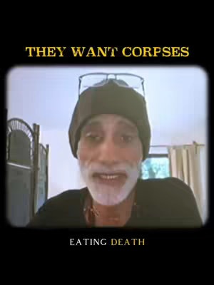 The image shows a man in a black hat and shirt against a blurry background. Overlayed on the image are the words 'THEY WANT CORPSES' at the top and 'EATING DEATH' at the bottom, inside a vintage film frame. The man has a white beard and is looking at the viewer.