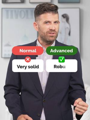 A man in a blazer stands in front of a background with framed art. Overlayed are UI elements showing English vocabulary. The man is the apparent subject of the video.