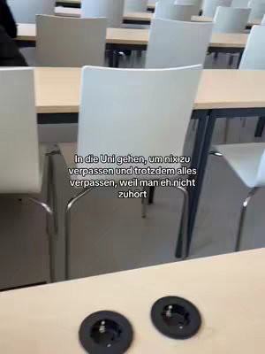 The image shows an empty university lecture hall. Rows of desks and chairs are visible. Text is overlaid on the image, describing the feeling of attending lectures without paying attention.