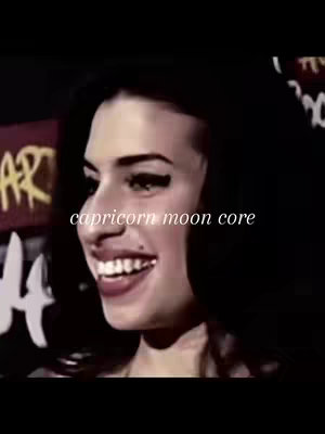 The cover image features a close-up of a woman from the shoulders up, turned slightly to her right. Her expression suggests gentle amusement. The text overlayed on the image says 'capricorn moon core', in a casual white font. The background is dark, creating strong contrast with the woman's light skin and dark hair. The overall composition is simple but striking, with the woman's face being the main focus.
