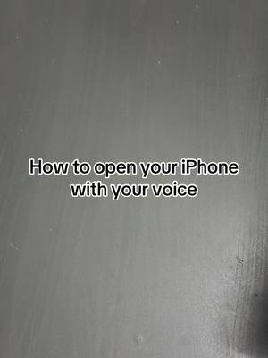 The cover image features a gray patterned background, likely a tabletop or surface. Centered on the image is overlay text, written in a clean, simple white font, stating, "How to open your iPhone with your voice."
