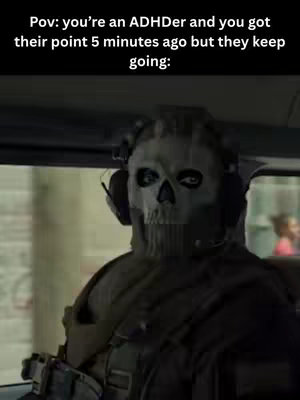 Image from a seated, character in a military styled outfit, the main focus being a skull mask with headphones.