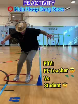 A person, presumably a PE teacher, is captured mid-stride on a wooden gymnasium floor. A red hula hoop is on the floor close to the person. Text overlays indicate it is a 'PE ACTIVITY' called 'Hula Hoop Drag Race.' Additional text reads 'POV: PE Teacher Vs Student'. The image has a bright, clean composition, with a background of gym equipment.