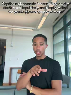 A man is standing in front of a bright background, pointing his index finger towards the viewer. The image has text at the top explaining the topic of the video. The man is wearing a black shirt and a gold bracelet.