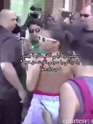 The image shows Selena Gomez surrounded by people, likely in a public setting. She is wearing sunglasses. The text overlaid in Arabic implies a discussion on Selena's personal life.