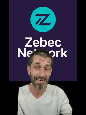 The cover image features a man in the foreground with a blurred background. The background has a purple hue with the Zebec Network logo prominently displayed. Below the logo, the text "Zebec Network " is visible in white font. The man is smiling and looking towards the camera, and appears to be in front of the logo. The overall composition is centered, with the man's face and the logo being the most prominent elements.