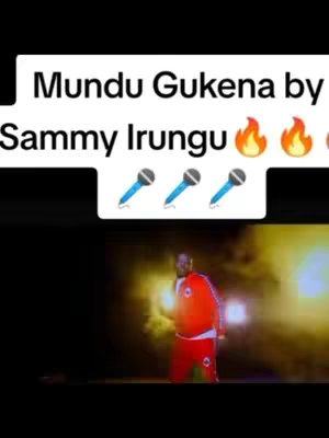 The cover image features a man in a red and white tracksuit standing and singing on stage with spotlights behind him. Above him, text in a white box says "Mundu Gukena by Sammy Irungu"; graphic elements include flame emojis, with microphone icons below the text.