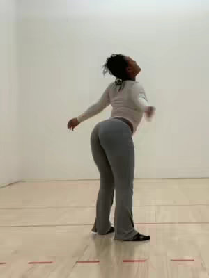 The cover image shows a woman standing in a room with brown flooring and white walls. The woman is turned away from the camera, with her upper body facing upwards. She is wearing a white long-sleeve shirt and gray sweatpants. The image has a neutral background.