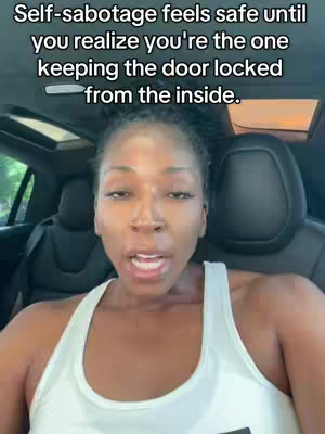 A woman sits inside a car, facing the camera, which is also filming from the car. Overlayed white text fills the top of the screen.