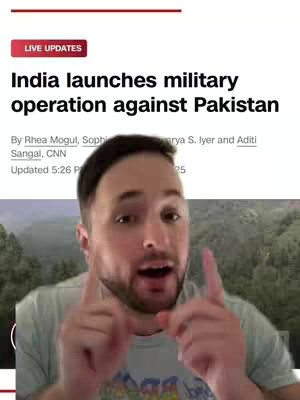 A man with short brown hair and a beard is pointing with both index fingers at the viewer. He is overlaid on a screenshot of a news article reporting on India launching a military operation against Pakistan, further overlaid onto a blurry green-toned background.