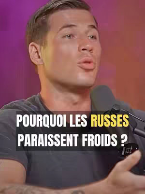 A man in a gray t-shirt is speaking into a microphone. A text overlay states "POURQUOI LES RUSSES PARRAISSENT FROIDS ?"