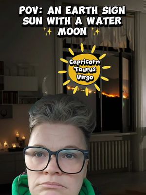 The cover image features a person wearing glasses centered at the bottom, with overlaid text at the top. Behind, through a window, is a dark outdoor scene with a fiery glow. A zodiac graphic is also present.