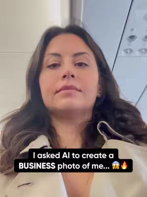 A woman is seen in the image, shot from a slightly upward angle, likely from her perspective. She is inside what appears to be an airplane. The upper portion of the image shows the plane's ceiling, including overhead compartments and air vents. The woman looks directly at the camera, her expression neutral. She has dark hair and is wearing a light-colored top or jacket. A text overlay at the bottom reads: 'I asked AI to create a BUSINESS photo of me…', accompanied by emoji of a shocked face and flames.