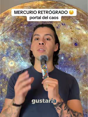 A man with dark hair and a navy blue T-shirt is centered in front of a space-themed blurred background. Above his head is a white rectangular overlay with black text. He is holding a microphone with a colorful patterned design, the background is an image of a planet similar to mercury, and the words "gustaría" is written at the bottom of the image. The image portrays a professional presentation.