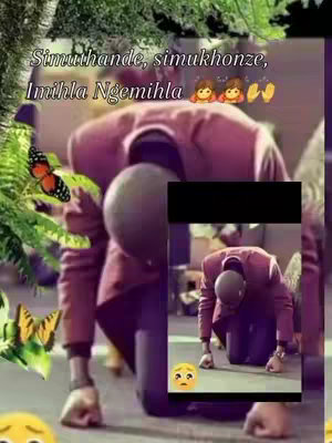 The cover image is a vertically oriented composite. The background is a blurred setting with hints of green foliage, potentially a garden or outdoor area. Overlaid on this is a figure in a pink suit, kneeling with their head down and back arched. A smaller inset image shows the same figure but in a separate, zoomed-in frame, kneeling as well. Additional graphics include emojis, a butterfly, and text in the top of the image.