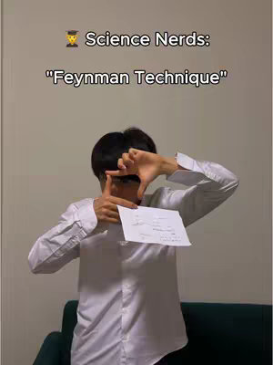 A person is framing their face with their hands, holding a paper with notes in front of them, with text overlays in the upper portion of the screen indicating a study technique.