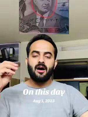 A medium shot features a man in a gray t-shirt, looking at the camera with his mouth open. Above the man, in the background, there is a currency note partially visible, with a red circle highlighting a portrait. The overlay text states: 'On this day' and 'Aug 1, 2023'. The background is a blurred interior.