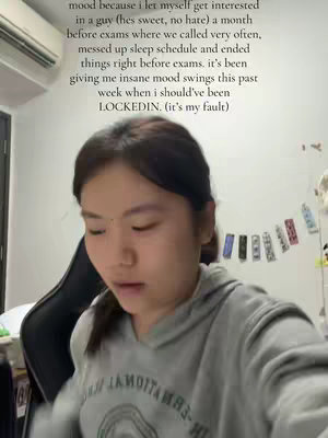 A young woman in a grey hoodie is the central focus, slightly angled and looking downward. Text in white font is overlaid on the image with a caption about a tough time during exam season.