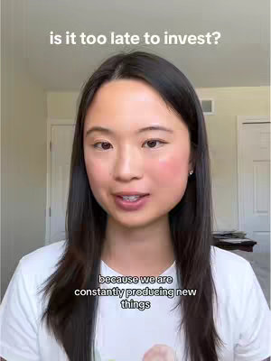 A woman with long, dark hair and a white t-shirt is centered in a vertical video frame. Above her head, the text overlay is displayed. Below her is additional text. The background is a minimalist interior with white doors.