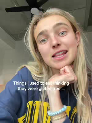 A selfie-style shot featuring a young woman with blonde hair, looking slightly upward and to the right, with a thoughtful expression. She rests her chin on her hand, and text overlays the image. The background appears to be a ceiling with a fan.
