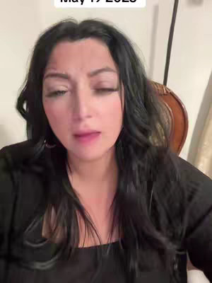 A woman with long black hair and dark clothing is looking at the camera. The top of the cover says "May 19 2023"