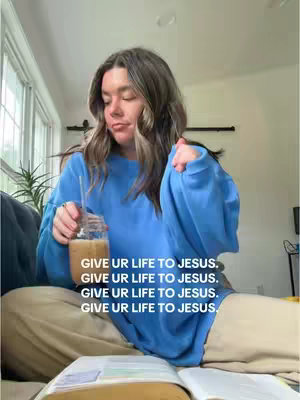 A woman in a blue sweatshirt sits, holding a drink and a book, with overlaid text.