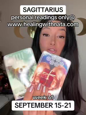 A woman with long dark hair holds up two tarot cards in front of her. The background is a plain wall with a crescent moon decoration. The text overlay indicates the reading is for Sagittarius for the week of September 15-21 and provides a website for personal readings.