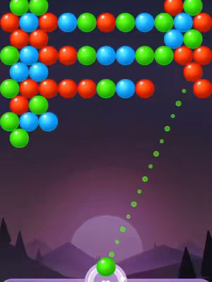 The image is a screenshot from a bubble shooter game. The layout is vertically oriented, featuring a dark purple gradient background with a stylized mountain range and a setting sun or moon. Rows of colored bubbles (red, green, blue) are arranged at the top, forming the game board. Below, a green bubble is being launched with a dotted trajectory line indicating its path. The game interface is minimalist and the colors are vibrant.
