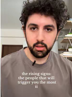 A man with curly hair, wearing a grey t-shirt, is centered and looking at the camera. Text is overlaid on his chest.