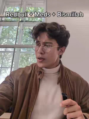 The cover image shows a young man with curly dark hair and round glasses looking towards the right while holding a black object. He's wearing a white turtleneck and a brown corduroy jacket. The background features a window.