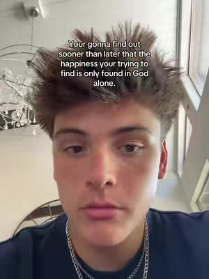 A selfie-style video cover featuring a young man looking directly at the camera. He has short, tousled brown hair. The background is blurred, suggesting an indoor setting. Overlaid text is present, conveying a motivational or religious message, positioned above the man's head.