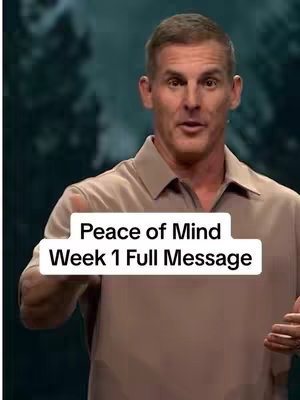 The image shows a man speaking in front of a soft background. He is wearing a light brown shirt. Text overlay indicates the video is about mental health.