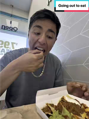 A young man is shown mid-bite, with a box of food visible at the bottom. Above, a text box indicates the content's focus, and the scene is set indoors.