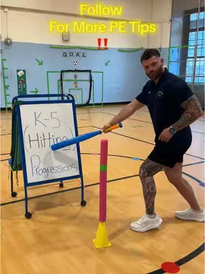 A man in athletic attire stands in a gym, holding a baseball bat and pointing toward a tee and sign. The background includes a basketball court and a goal.