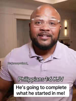 A medium shot features a bald, Black man wearing glasses and a light purple polo shirt. His expression is open and earnest, with a slight smile. Text overlays the bottom of the image, quoting a Bible verse. The background shows a blurred room interior.