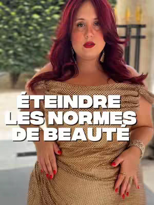 The cover shows a woman with long red hair and red lipstick. She is wearing a gold, woven dress with a plunging neckline and her hands are placed just below her chest. A text overlay is centered. The background is blurred, portraying a lush green setting.