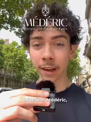 The cover image shows a young man in front of a building, holding up a small microphone. The upper part of the image has a logo with the word MÉDÉRIC and below it, slightly smaller text. The background has trees and the rest of the city scenery.