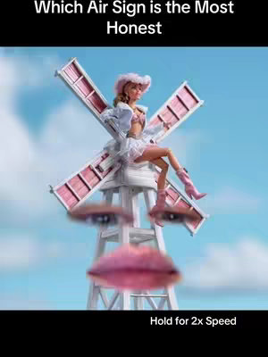 The cover image shows a surreal scene with a windmill. In the center, a woman sits on one of the windmill's blades, looking off to the viewer's right. She is dressed in a pink dress and hat, and matching boots. The face of the windmill is formed by a pair of eyes and a mouth, creating the illusion of a face. The background is a blue sky with some clouds. Below the image, the text reads "Hold for 2x Speed".