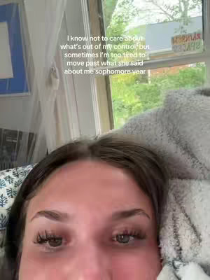 A close-up shot of a person lying down, looking up with a slightly distressed expression. Text overlays are present adding to the context.