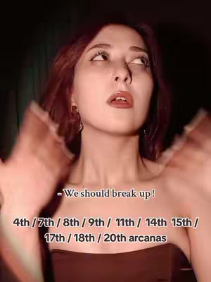 A person with auburn hair is centered in the frame, looking up with a mildly surprised expression. A text overlay near the person's face lists various arcane numbers and the phrase "-We should break up!" The background is dark, and the person is wearing a strapless top.