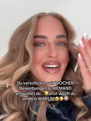 A close-up shot of a woman's face, with her blonde hair framing it. She's smiling and looking towards the camera with a slightly surprised expression. Overlayed text communicates a message about job applications.