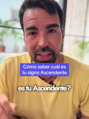 A man with short dark hair and a beard is centered against a blurred background. He is wearing a yellow t-shirt. A blue rectangular box with white text overlays his chest. The text in the box reads: "Cómo saber cuál es tu signo Ascendente?" Underneath the box is the text: "es tu Ascendente?"