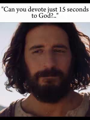 The image shows a medium shot of a man with long, dark hair and a full beard, reminiscent of a classical depiction of Jesus. He is looking slightly off-center to the left, with a thoughtful expression. The lighting is soft, creating a sense of serenity. A text overlay at the top asks if the viewer can devote 15 seconds to God.