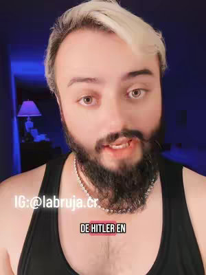 A medium shot of a man with a beard and light-colored hair, speaking directly to the camera. Below his neck is a black top. The name of an Instagram account is displayed on the upper left and a text overlay is placed below his neck.